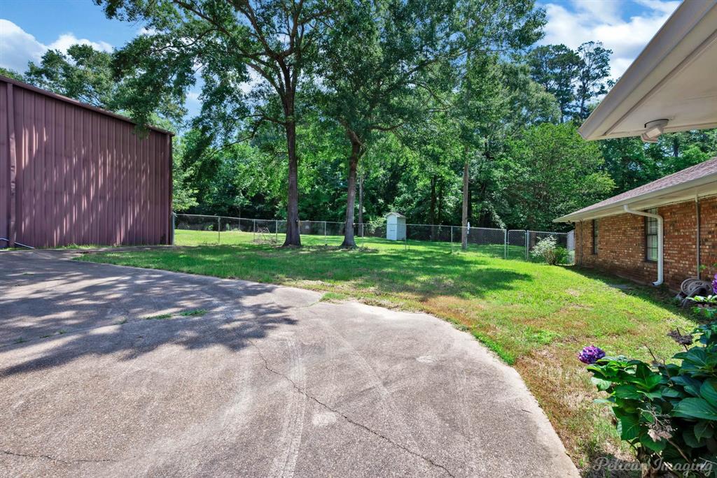 8344 Odom Road Greenwood, LA 71033 - Photo 36 of 39 Fenced backyard featuring a storage shed and view of scattered trees