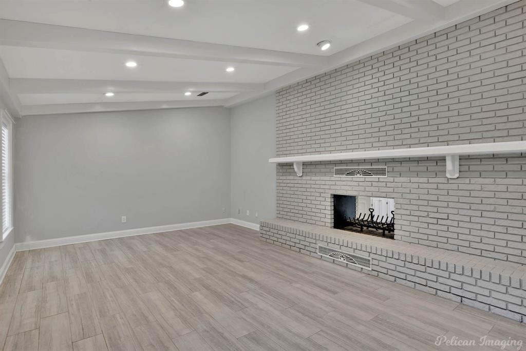 8344 Odom Road Greenwood, LA 71033 - Photo 5 of 39 Unfurnished living room with beamed ceiling, a fireplace, wood finished floors, recessed lighting, and brick wall
