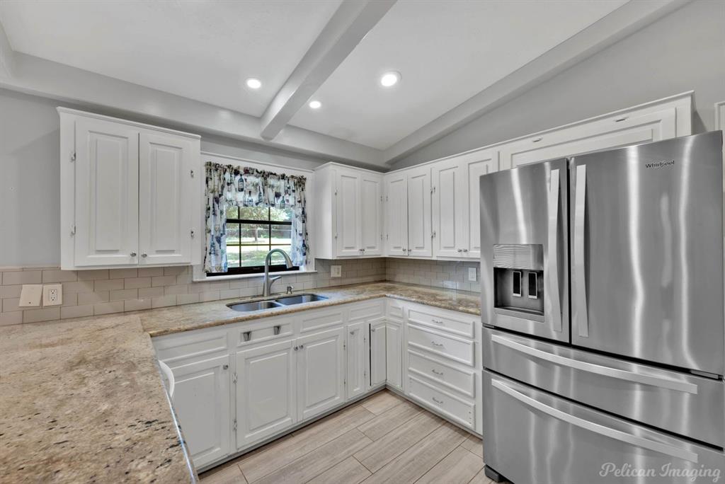 8344 Odom Road Greenwood, LA 71033 - Photo 9 of 39 Kitchen with stainless steel fridge, beamed ceiling, tasteful backsplash, white cabinets, and recessed lighting