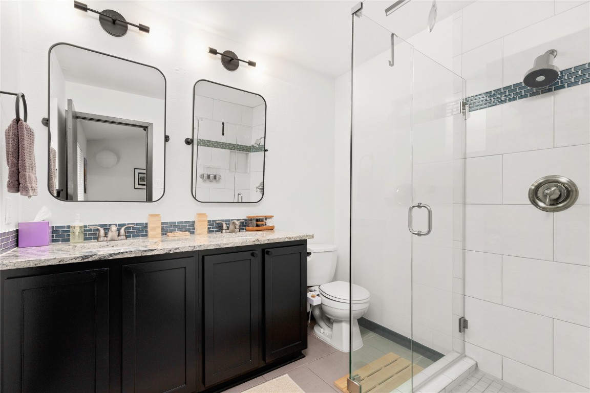 705 Battle Bend Boulevard Austin, TX 78745 - Photo 13 of 27 a bathroom with a double vanity sink mirror and shower