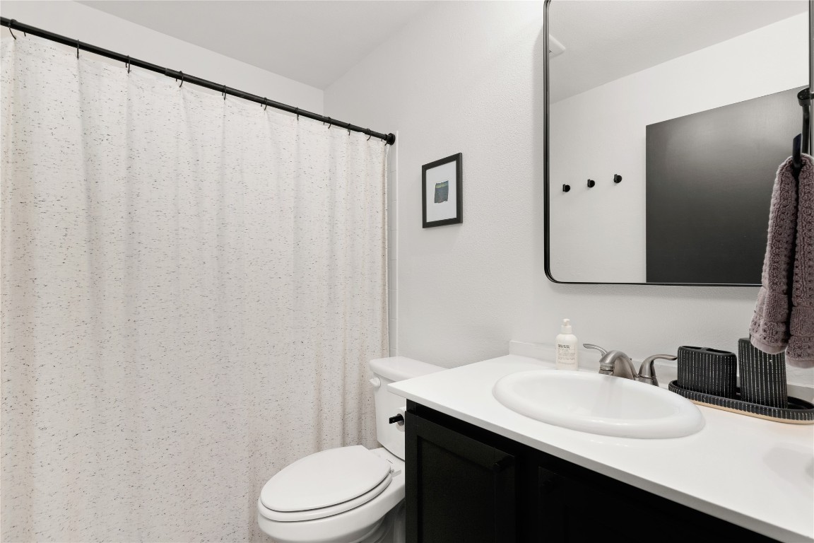 705 Battle Bend Boulevard Austin, TX 78745 - Photo 19 of 27 a bathroom with a sink vanity mirror and toilet