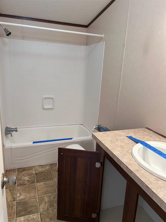 329 Canvas Back Drive Princeton, LA 71067 - Photo 17 of 20 Guest bath with vanity, shower combination, crown molding, and a textured ceiling