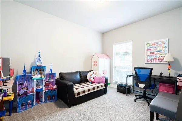 a living room with furniture a rug and a desk