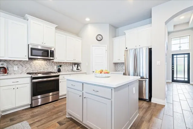 a kitchen with stainless steel appliances a stove microwave and a refrigerator