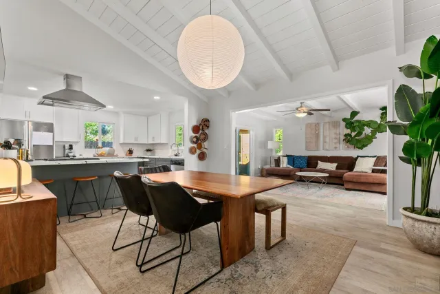 a dining hall with stainless steel appliances kitchen island granite countertop a table and chairs in it