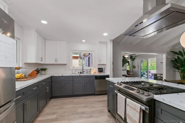 a large kitchen with stainless steel appliances granite countertop a stove and a sink