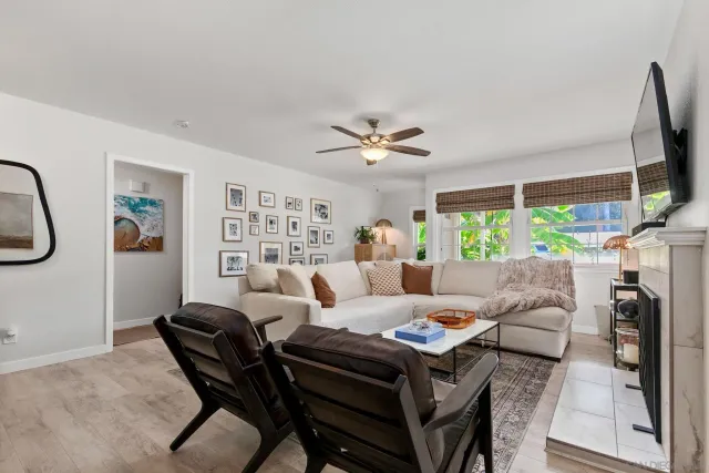 a living room with furniture a flat screen tv and a floor to ceiling window
