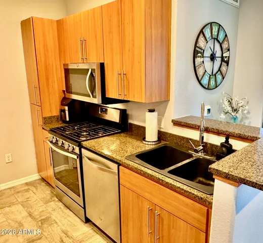 a kitchen with stainless steel appliances granite countertop a refrigerator and a sink