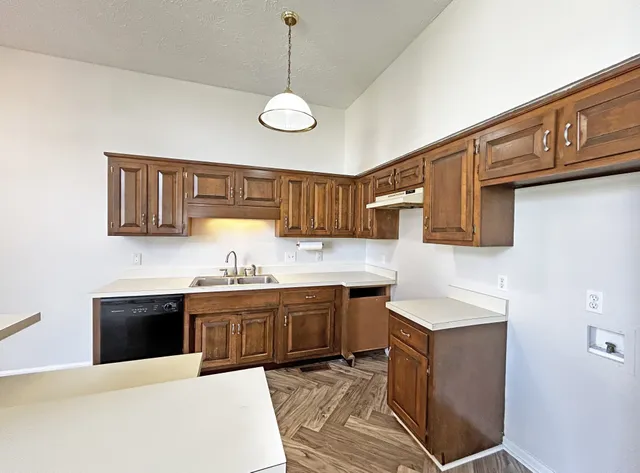 a kitchen with stainless steel appliances granite countertop a sink and dishwasher a stove with wooden floor