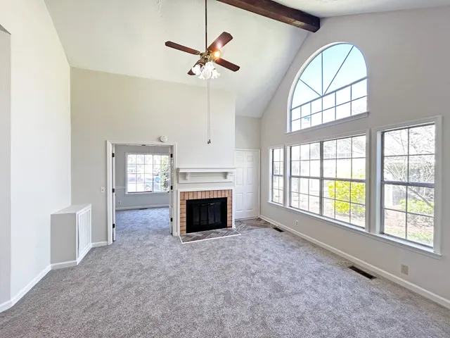 a view of an empty room with a fireplace and a window