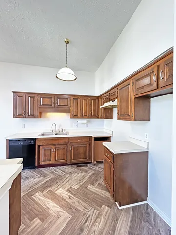 a kitchen with a sink refrigerator and cabinets