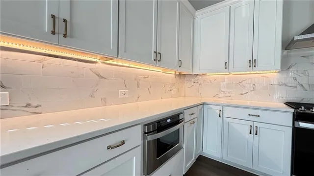 a view with granite countertop white cabinets and a sink