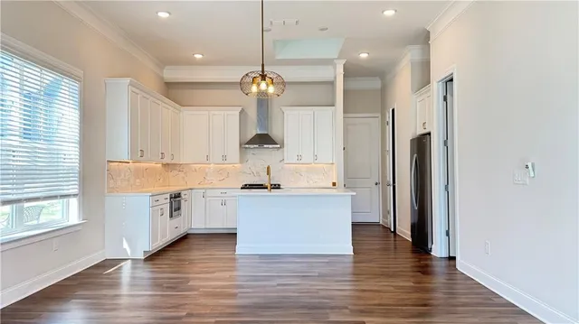 a large kitchen with granite countertop a large center island a sink stainless steel appliances and cabinets