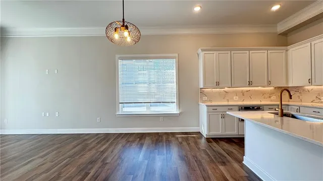 a kitchen with stainless steel appliances granite countertop cabinets a sink dishwasher and a stove with wooden floor