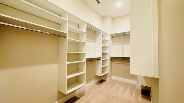 a view of walk in closet with empty racks