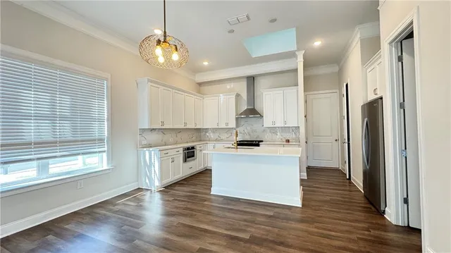 a kitchen with white cabinets and wooden floor