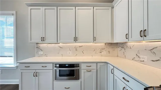 a view of a kitchen with white cabinets