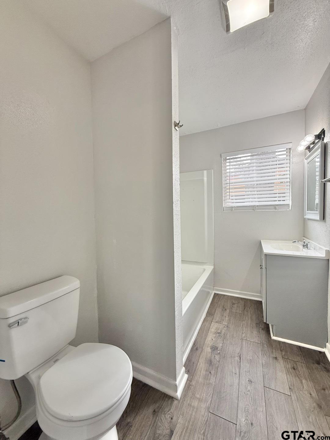 533 Bandera Drive Tyler, TX 75702 - Photo 13 of 18 a white toilet sitting next to a bathroom sink