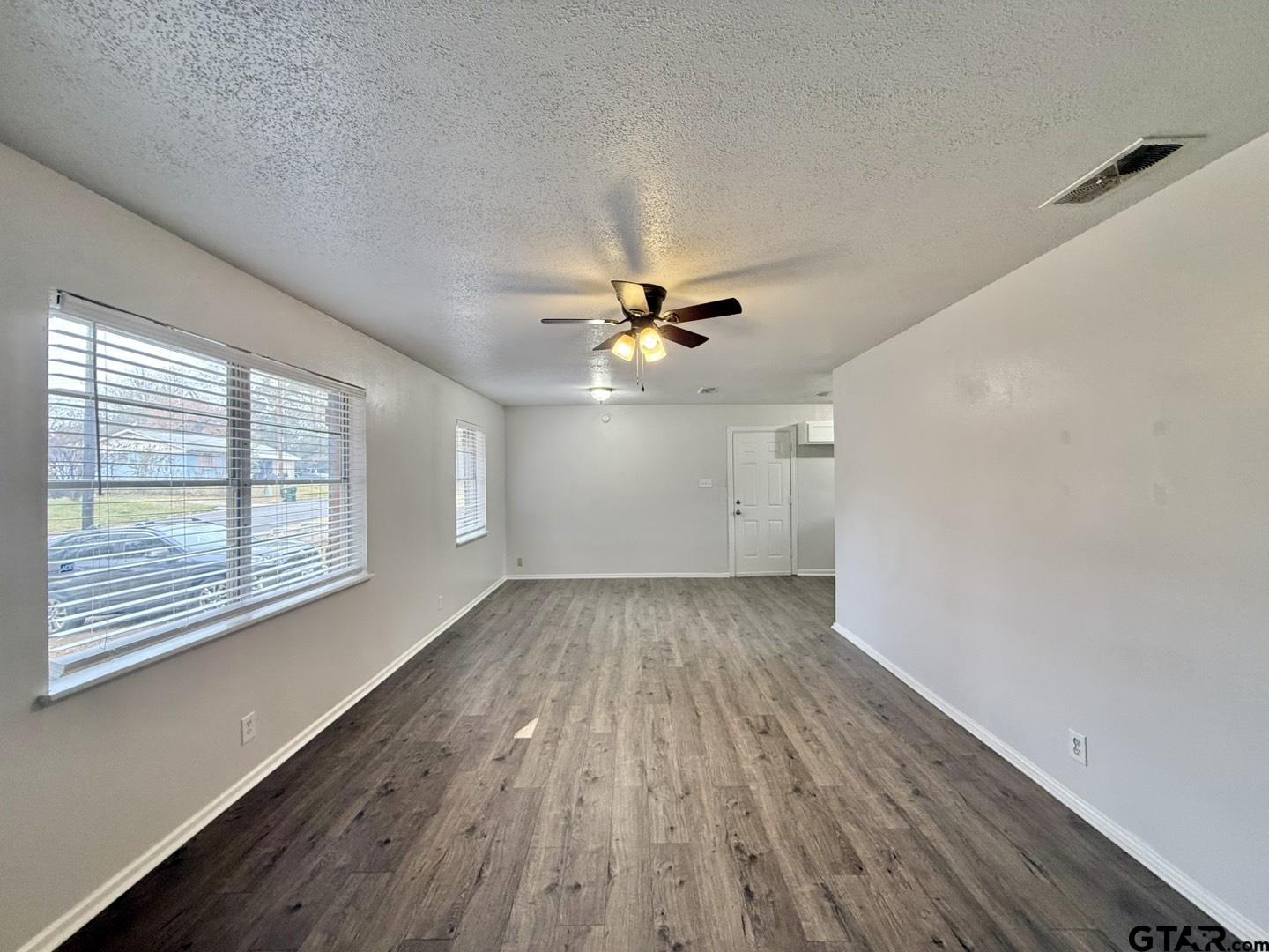533 Bandera Drive Tyler, TX 75702 - Photo 2 of 18 wooden floor in an empty room with a window
