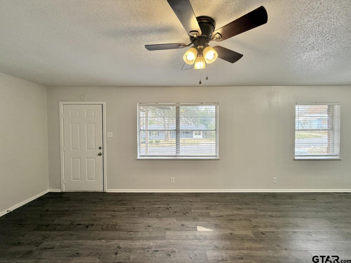 533 Bandera Drive Tyler, TX 75702 - Photo 3 of 18 a view of an empty room with window and wooden floor