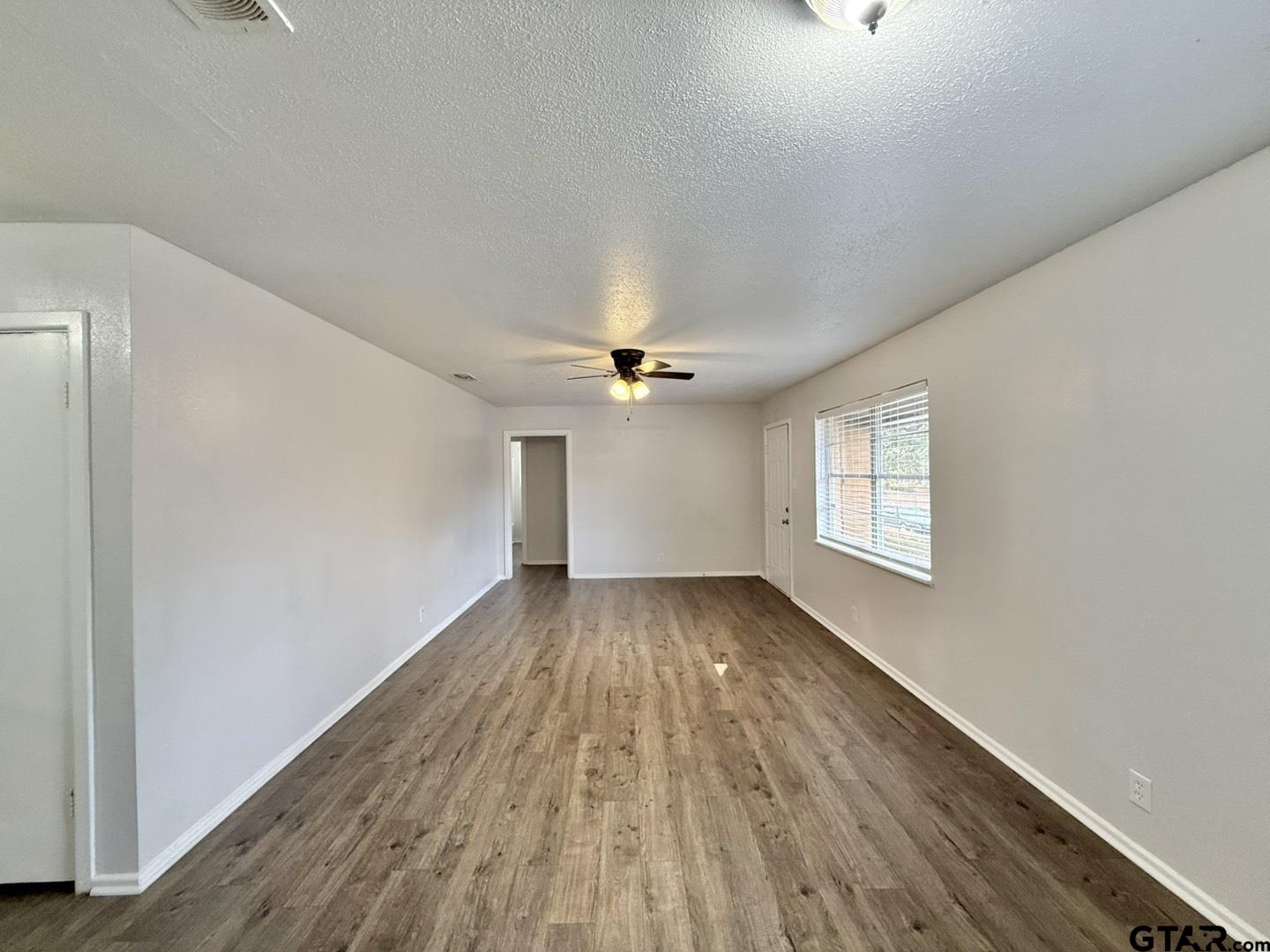 533 Bandera Drive Tyler, TX 75702 - Photo 4 of 18 wooden floor in an empty room with a window