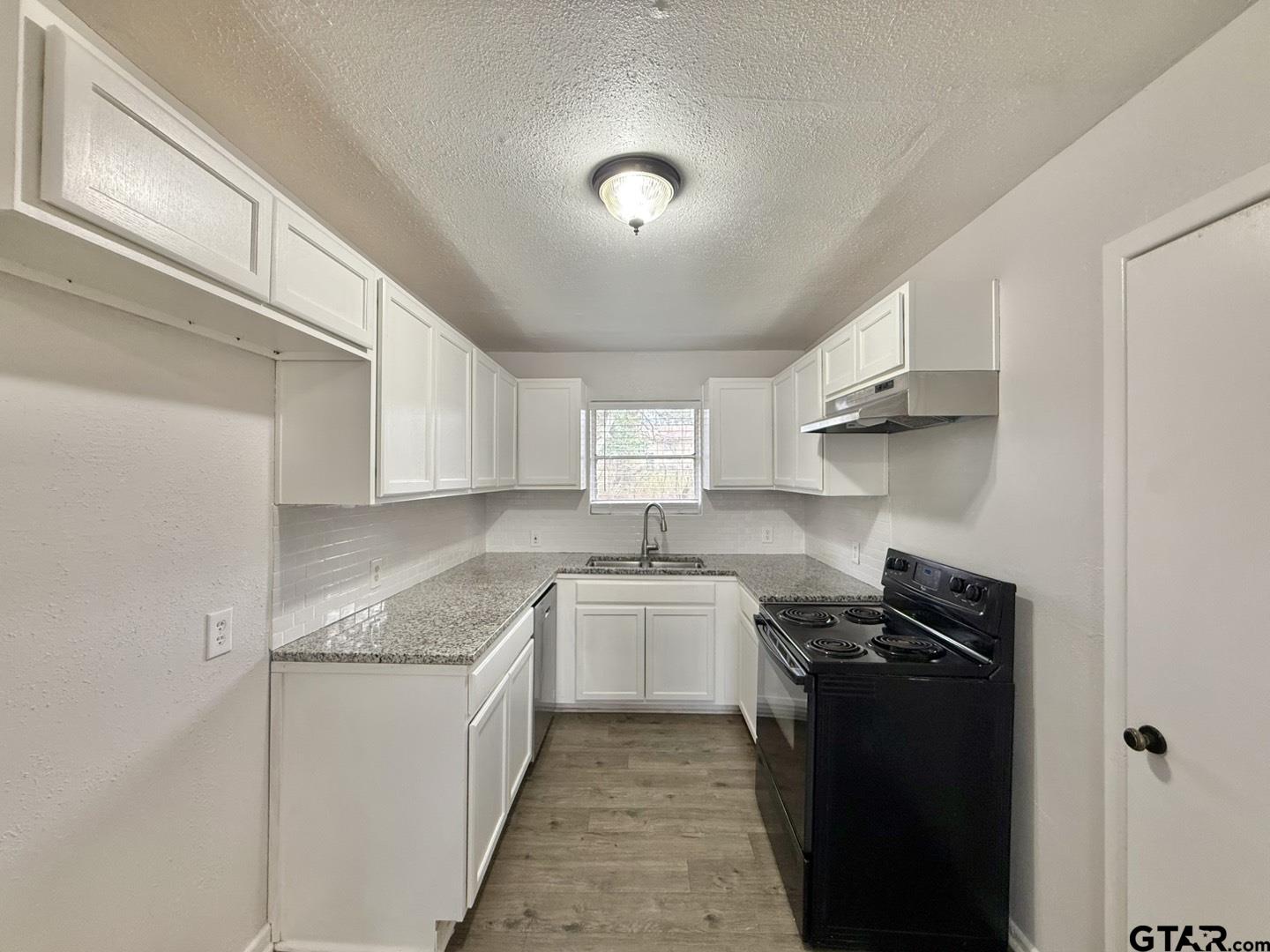 533 Bandera Drive Tyler, TX 75702 - Photo 6 of 18 a kitchen with a sink stove and cabinets
