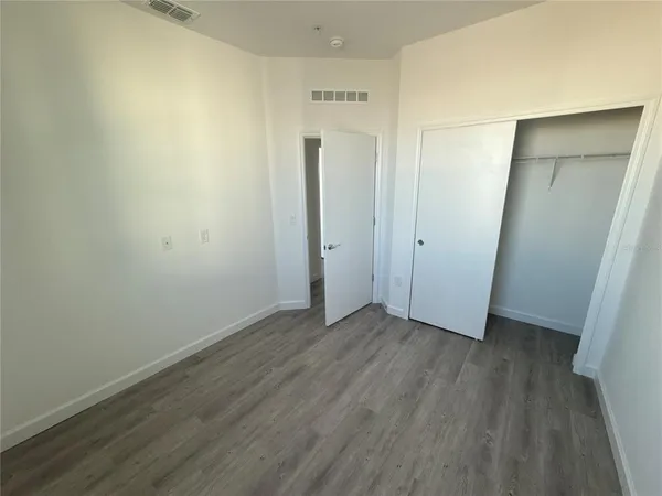 an empty room with wooden floor and closet