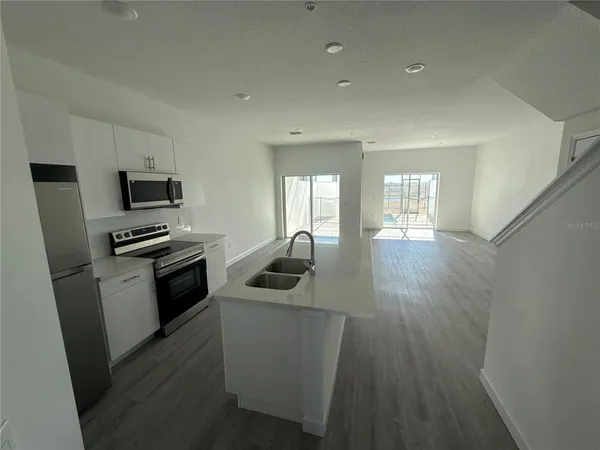 a kitchen with a sink and steel appliances