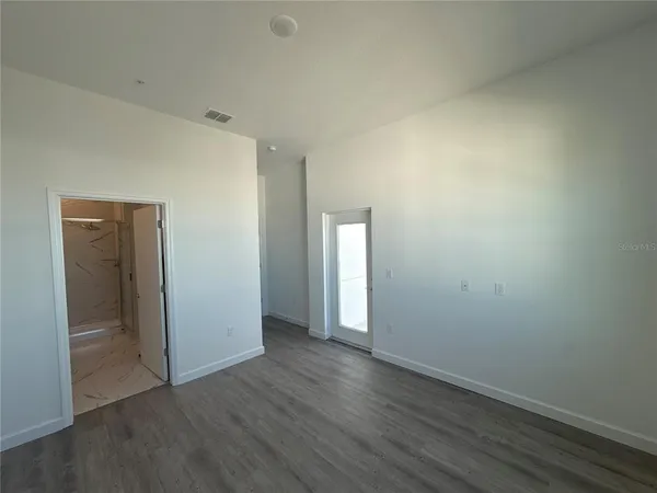 an empty room with wooden floor and closet