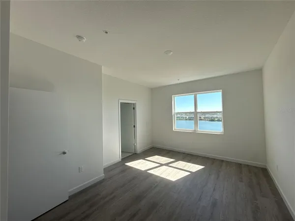 a view of empty room with wooden floor and window