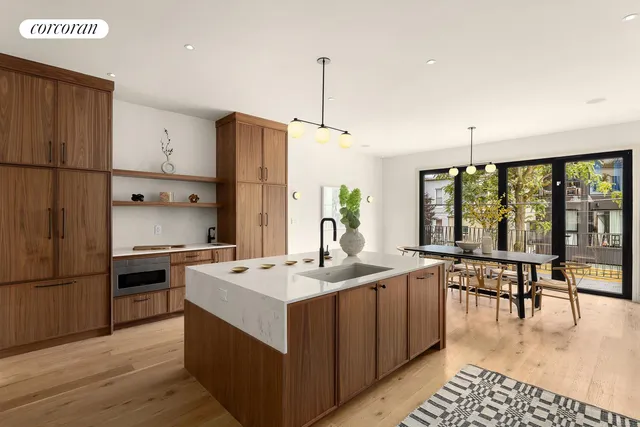 a kitchen with stainless steel appliances granite countertop a stove top oven a sink dishwasher and a dining table with wooden floor