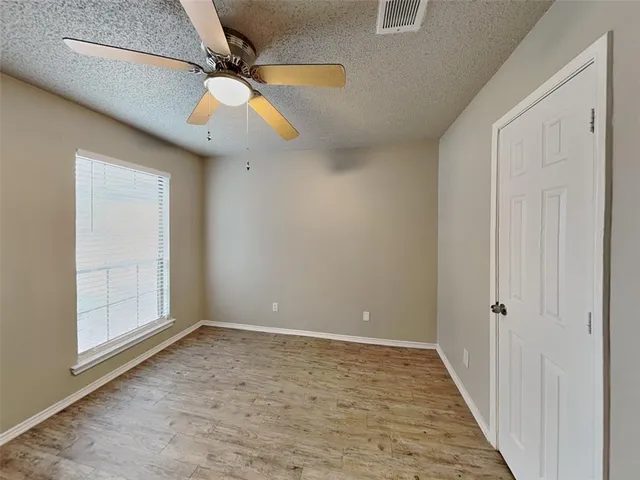 an empty room with a ceiling fan and carpet