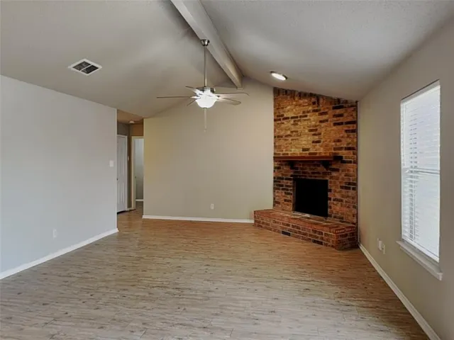 wooden floor in an empty room with a fireplace
