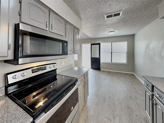 a kitchen with wooden cabinets and a stove top oven