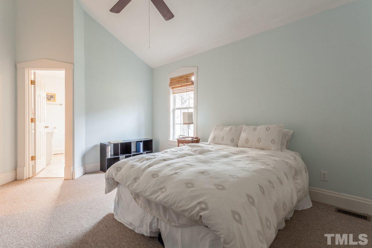 500 Frank Street Raleigh, NC 27604 - Photo 14 of 23 a large bed sitting in a bedroom next to a window and a chandelier