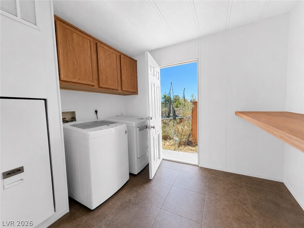1611 West Blosser Ranch Road Pahrump, NV 89060 - Photo 17 of 25 Functional laundry space with storage cabinets and outdoor access.