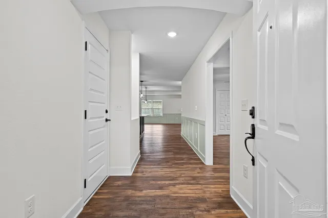 a view of a hallway with wooden floor and closet