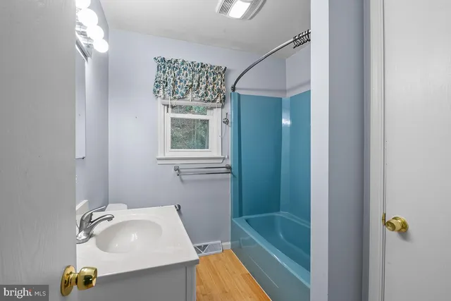 a bathroom with a tub sink and mirror