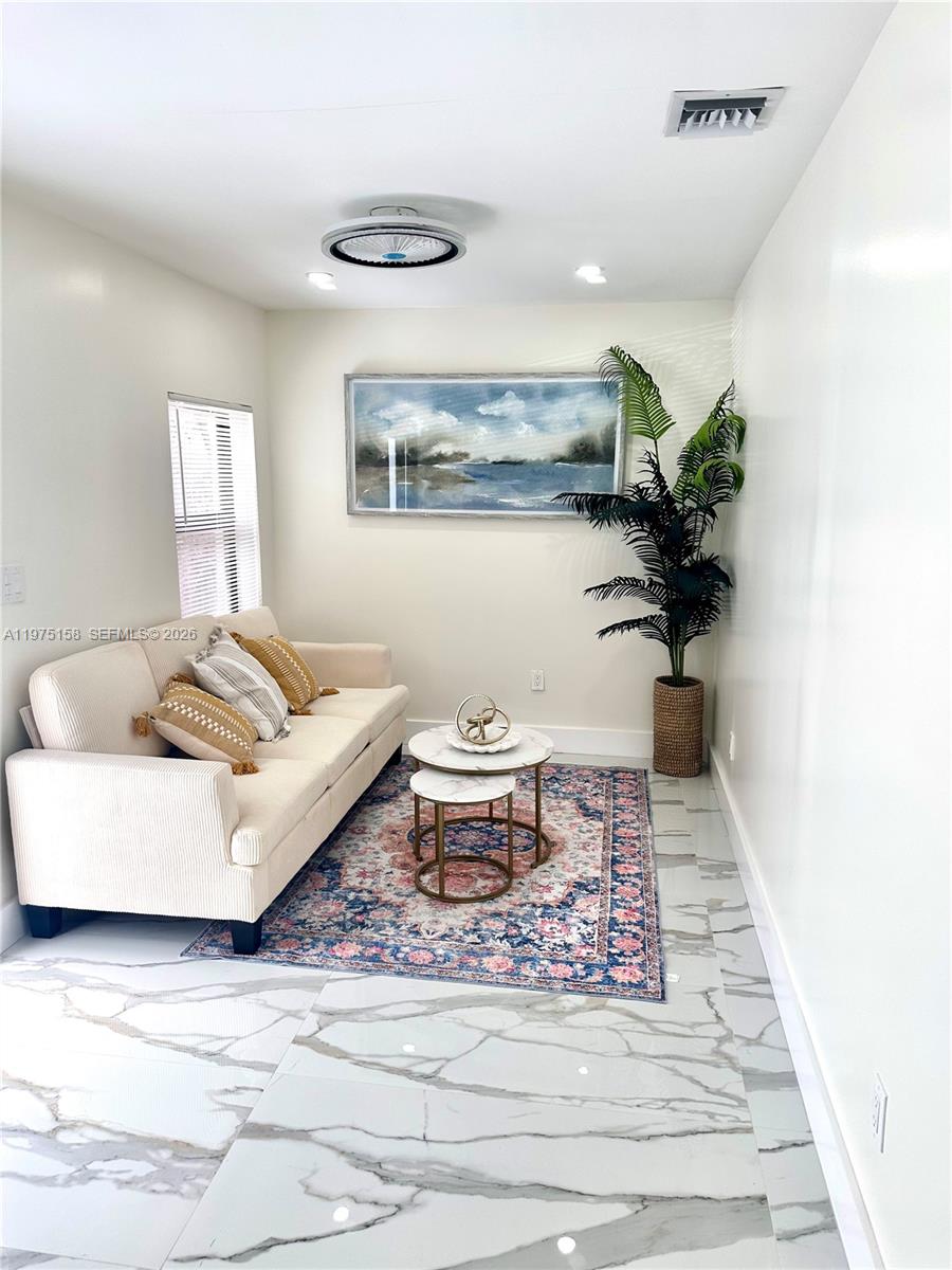 237 Northeast 110th Terrace, Unit 237 Miami, FL 33161 - Photo 2 of 12 a living room with furniture and a potted plant