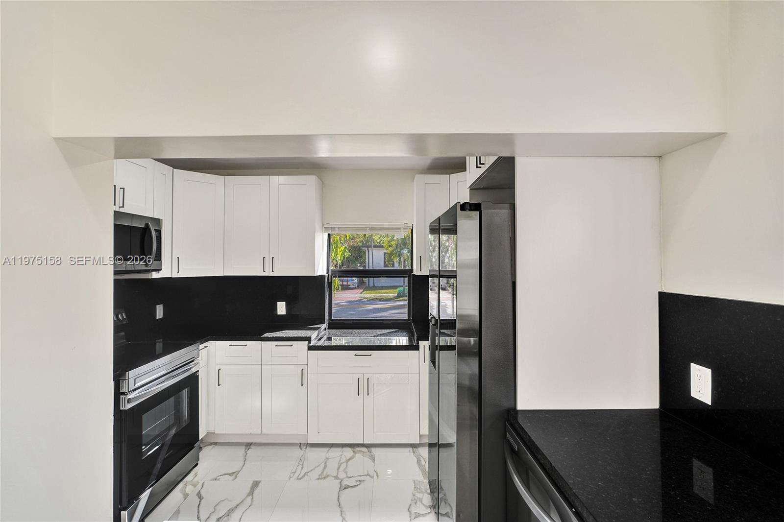 237 Northeast 110th Terrace, Unit 237 Miami, FL 33161 - Photo 5 of 12 a kitchen with a sink stainless steel appliances and cabinets