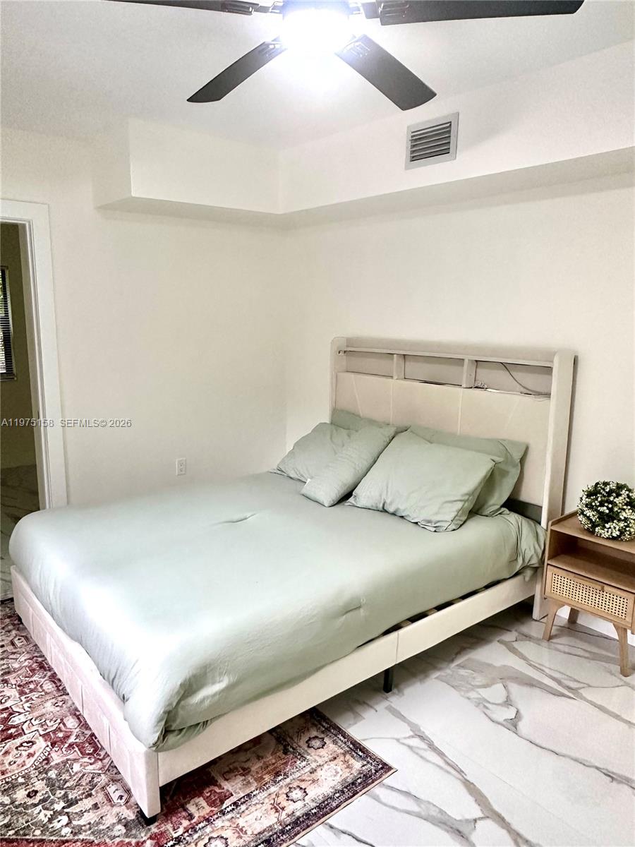 237 Northeast 110th Terrace, Unit 237 Miami, FL 33161 - Photo 6 of 12 a bed sitting in a bedroom next to a window