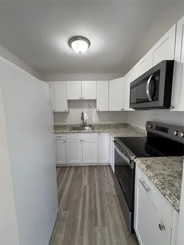 a kitchen with stainless steel appliances granite countertop a stove a sink and a microwave