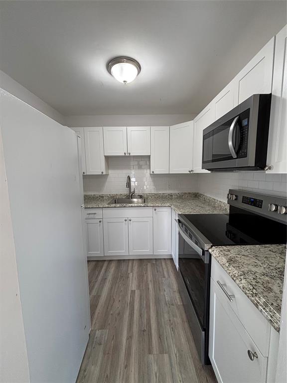 11003 Ridge Avenue, Unit A Fort Pierce, FL 34982 - Photo 4 of 10 a kitchen with stainless steel appliances granite countertop a stove a sink and a microwave