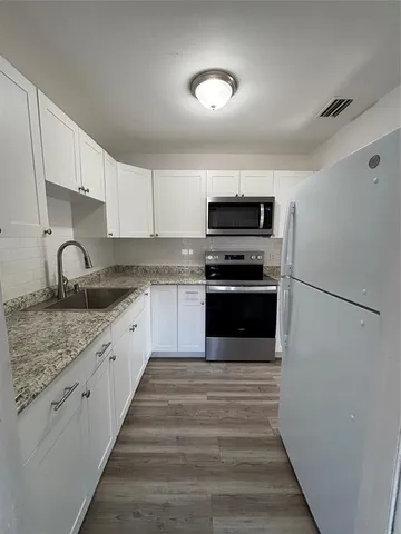 a large kitchen with a stove and a sink