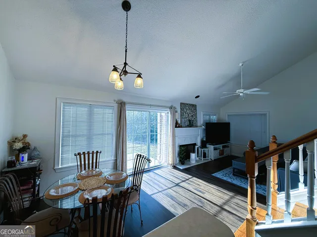 a kitchen with granite countertop a dining table chairs and a refrigerator