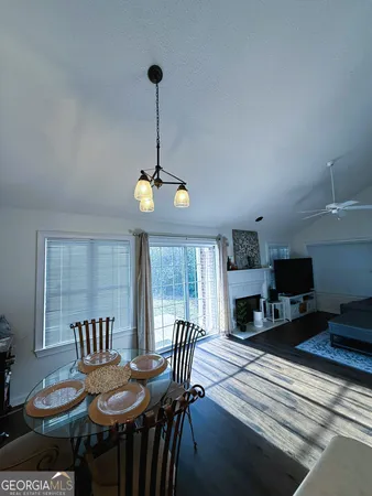 a view of a dining room with furniture a chandelier and wooden floor
