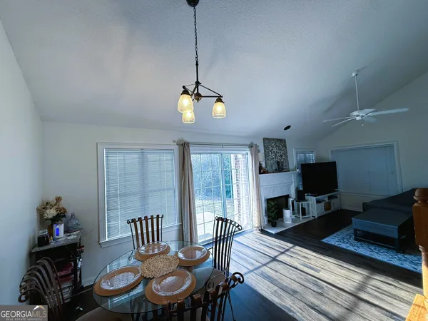 a view of a dining room with furniture a rug and wooden floor