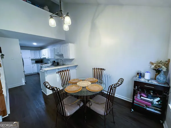 a kitchen with granite countertop a dining table chairs and a refrigerator
