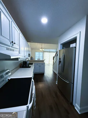 a kitchen with stainless steel appliances a refrigerator a sink a stove and cabinets