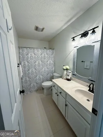 a bathroom with a double vanity sink toilet and shower